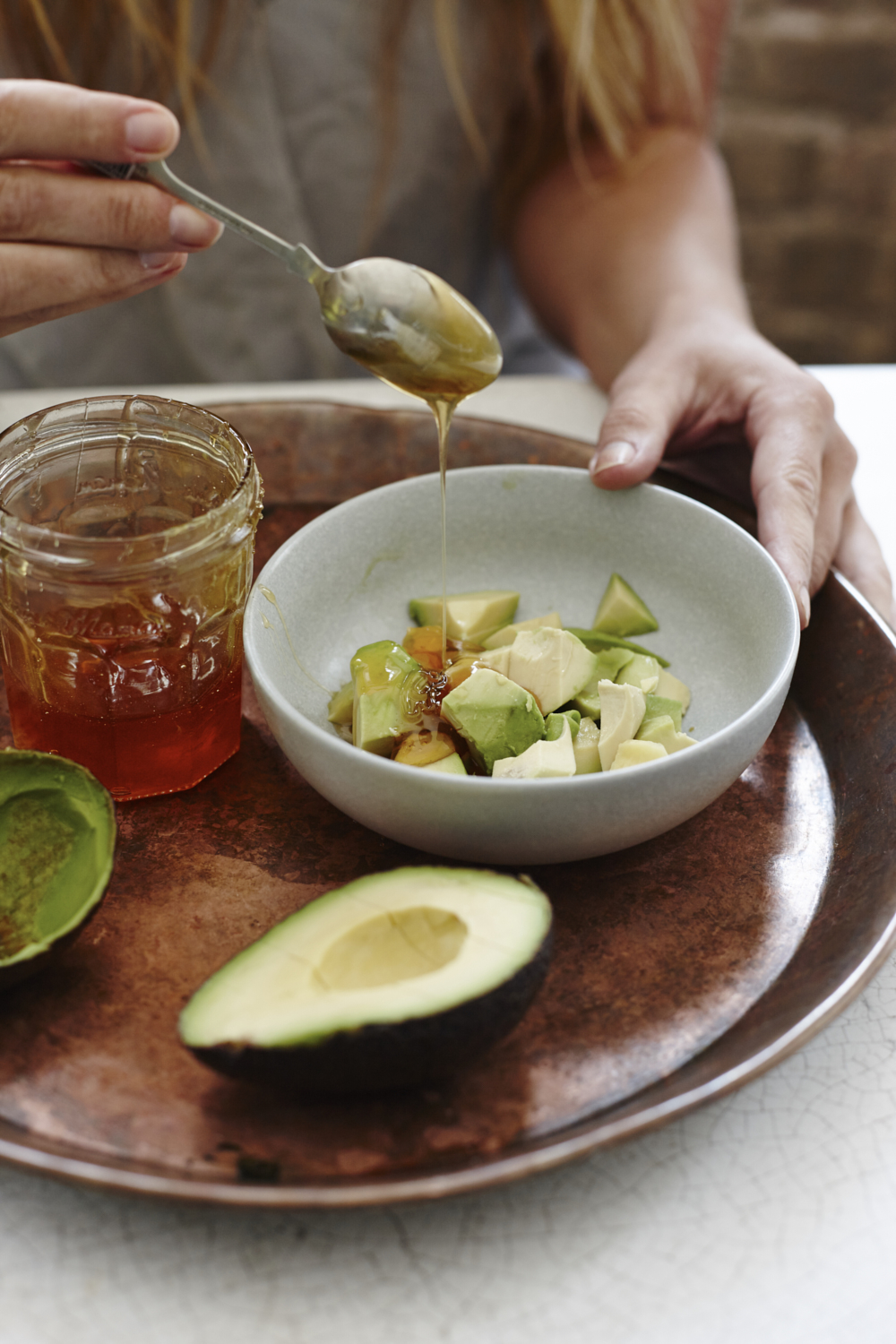Cleansing and softening avocado and manuka honey facemask. Food photography by Joanna Henderson