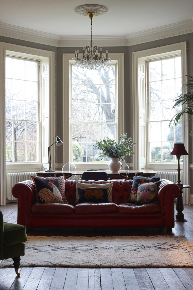 Margot Selby cushions on a red leather sofa. Berber rug. Interiors photographer Joanna Henderson