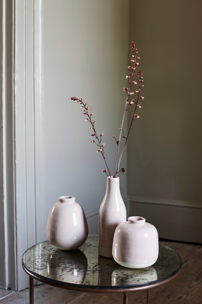 Pastel pink vases in various shapes on a mirrored table