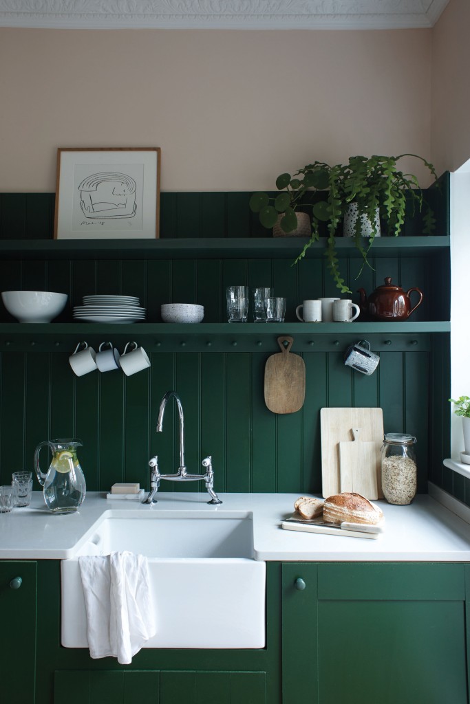 Farrow and Ball Kitchen worktop and sink area painted in green and pink with a selection of glasses, crockery and plants 